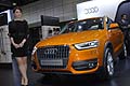 Ragazza che affianca la vettura Audi Q3 2.0 T quattro orange al Salone dellauto di Bologna